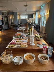 un lungo tavolo con molti piatti di cibo sopra di Visjon Gjestegård a Hokksund