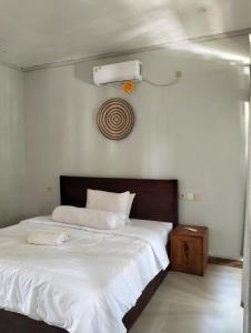 a bedroom with a large white bed with a fan at Kri Homestay in Kuta Lombok