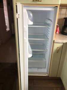 an empty refrigerator with its door open in a kitchen at Maison d’hôtes Au pied du Château in Saverne