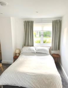 a bedroom with a large bed and a window at Self contained annex with full kitchen in Witney