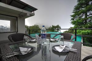 a glass table with a bottle of water on it at Hotel Lodge Hill Near Mall Road, Mussoorie in Mussoorie