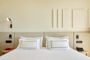 a large white bed with two pillows at Meliá Lloret de Mar in Lloret de Mar