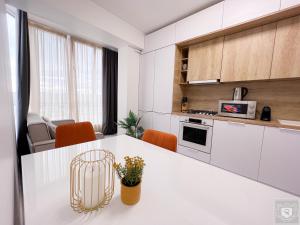 a kitchen with white cabinets and a white counter top at RentHouse Apartments Perla in Chişinău