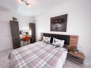 a bedroom with a bed with a checkered blanket at RentHouse Apartments Perla in Chişinău