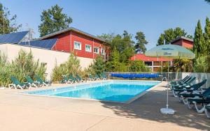 una piscina con sillas y sombrilla en Détendez-vous à Richelieu, en Chaveignes