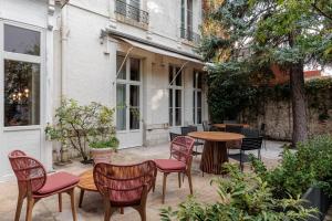 een patio met stoelen en tafels en een tafel en stoelen bij La Loge Gogaille - Arago - Accès autonome in Orléans
