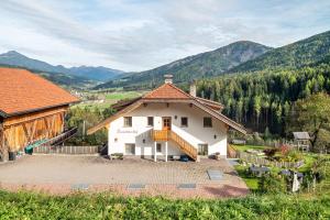 a large white house with a balcony and mountains at Kranebitterhof Apt Enzian in Valdaora