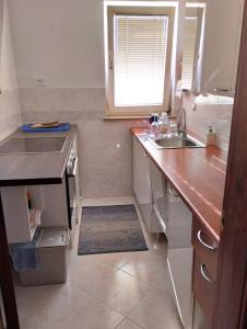 uma cozinha com um balcão, um lavatório e uma janela em Stan u samom centru Obrenovca, na Trgu 2 em Obrenovac