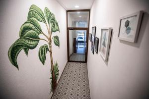 a hallway with a painting of a plant on the wall at Casa Mercedes in Panama City
