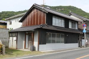 a black and white building on the side of a street at Womb Guesthouse Kojima -Uminomieru ie- - Vacation STAY 95107v in Tamano