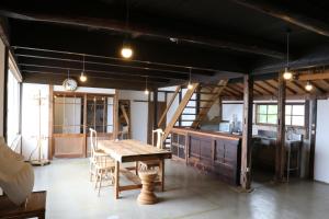 a dining room with a table and a kitchen at Womb Guesthouse Kojima -Uminomieru ie- - Vacation STAY 95107v in Tamano