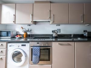 a kitchen with a washing machine and a microwave at Pass the Keys - Modern and spacious flat Near London Bridge in London