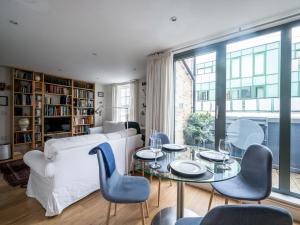 a living room with a white couch and a table and chairs at Pass the Keys - Modern and spacious flat Near London Bridge in London