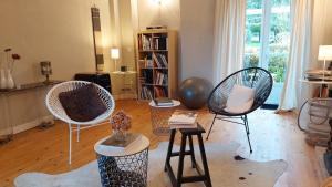 un soggiorno con 2 sedie e una libreria di La Loge du Grand Cèdre, chambre d'hôtes SoCosy a Fontcouverte
