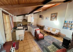 a kitchen and living room with a couch and a table at The Old Bakery in Alderney