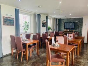 a restaurant with wooden tables and chairs and a tv at Hotel 21 in Bratislava