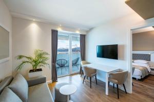 sala de estar con mesa y dormitorio en Alliance Palace Batumi en Batumi