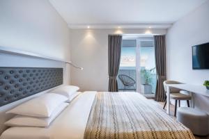 a hotel room with a bed and a desk and a window at Alliance Palace Batumi in Batumi