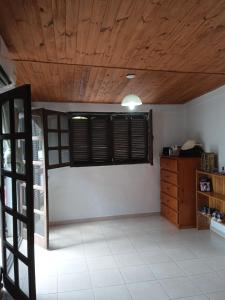 Cette chambre dispose d'une fenêtre et d'un plafond en bois. dans l'établissement El Valle Hostería, à Mina Clavero