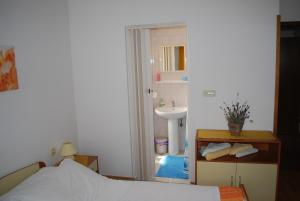 uma pequena casa de banho com uma cama e um lavatório em Sobe Ivančica em Rupa