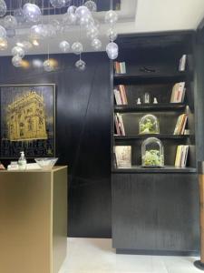 a room with a black wall and a shelf with books at Hôtel Elysées Paris in Paris