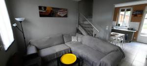 ein Wohnzimmer mit einem grauen Sofa und einem gelben Tisch in der Unterkunft Maison de charme à Rouen Max 10 personnes in Rouen