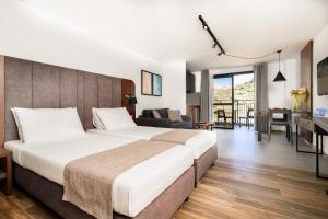 a bedroom with a large bed and a living room at Luna Holiday Complex in Mellieħa