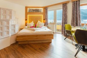 a hotel room with a bed and a table and chairs at Kamenhof in Weissensee