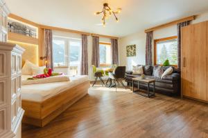 a bedroom with a bed and a couch and a table at Kamenhof in Weissensee