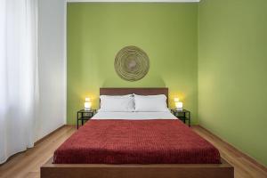 sypialnia z łóżkiem z czerwoną narzutą i 2 lampami w obiekcie Classbnb - Ampio appartamento a 1km da CityLife w Mediolanie