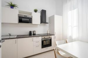 a kitchen with white cabinets and a white counter top at Classbnb - Ampio appartamento a 1km da CityLife in Milan
