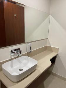 a bathroom with a white sink and a mirror at The Kedar Resort in Mathura