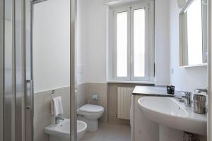 a white bathroom with a toilet and a sink at Classbnb - Ampio appartamento a 1km da CityLife in Milan