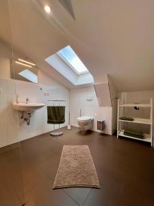 ein Badezimmer mit Toilette und Waschbecken und einem Oberlicht in der Unterkunft Ferienwohnungen Am Kaufmannshof in Quedlinburg