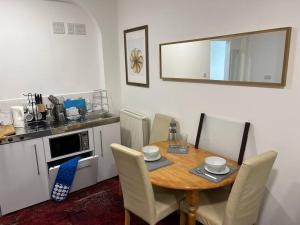 a kitchen with a wooden table with chairs and a counter at Impressive Large StudioWoodford in Woodford Green