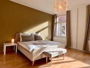 Schlafzimmer mit einem Bett, einem Fenster und einem Kronleuchter in der Unterkunft Ferienwohnungen Am Kaufmannshof in Quedlinburg