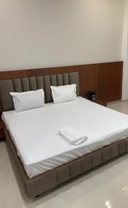 a large bed with two white towels on it at The Kedar Resort in Mathura
