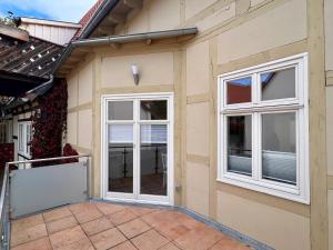 ein Haus mit 2 Fenstern und einer Terrasse in der Unterkunft Ferienwohnungen Am Kaufmannshof in Quedlinburg