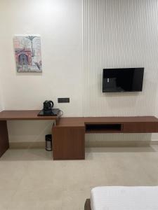 a room with a desk with a television on a wall at The Kedar Resort in Mathura