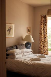 - une chambre avec un lit doté d'une lampe et d'une fenêtre dans l'établissement Thirsk Hall South Wing, North Yorkshire, à Thirsk
