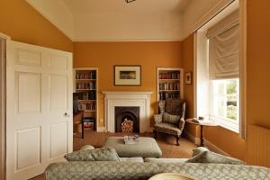 a living room with a couch and a fireplace at Thirsk Hall South Wing, North Yorkshire in Thirsk