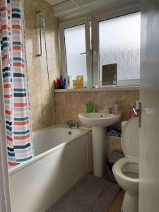 a bathroom with a tub and a toilet and a sink at Central London Spacious Double Room in London