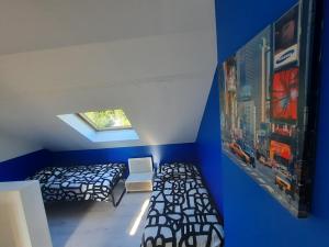 1 dormitorio con 2 camas y pared azul en Maison de charme à Rouen Max 10 personnes en Rouen