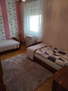 1 dormitorio con 2 camas y ventana en SIESTA vendégház en Kiskunhalas
