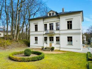 ein großes weißes Haus mit einem Kreis im Hof in der Unterkunft Villa Theresa - Ferienwohnung 1 in Neuhof