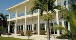 a large white building with palm trees in front of it at The Peak Surf House in Huu