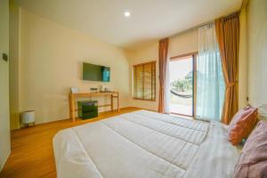 a bedroom with a large bed with a large window at Pai Nam Now in Pai