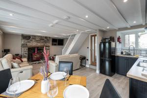 a kitchen and living room with a table and a refrigerator at Neigwl View in Llanfihangel Bachellaeth