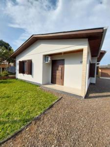 a small white house with a garage at Pousada Paraíso dos Canyons in Praia Grande