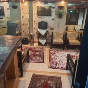 un soggiorno con tappeti, tavolo e sedie di San mina Hotel a Luxor
